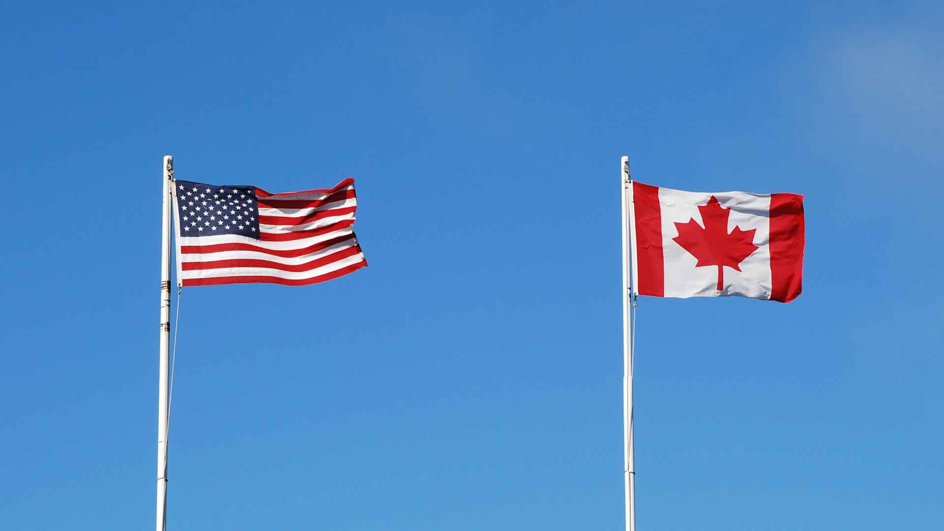 Cross-Border A picture of the U.S. and Canada border with the flags side by side.