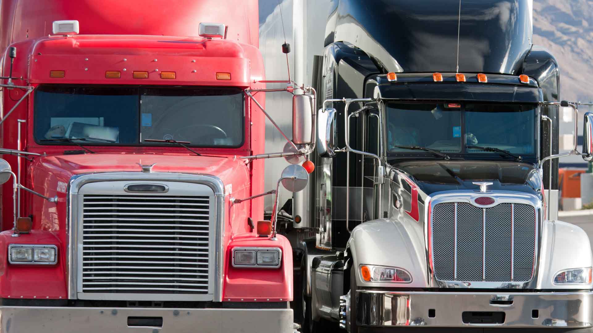 Two semi tractors coming head-on, moving side by side in