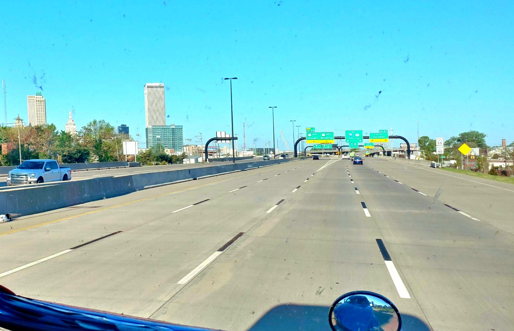 A picture taken from behind the windshield of a deserted interstate.