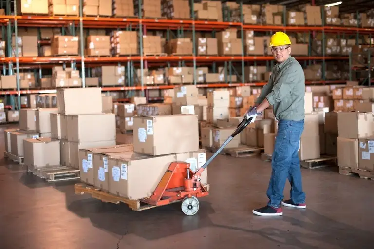 male warehouse worker operating pallet jack